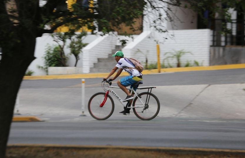 Un hombre pedalea su bicicleta por la Vía Libre en San Pedro Garza García, Nuevo León.